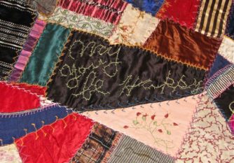 Detail of a crazy quilt with an embroidered patch